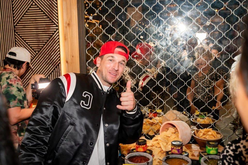 Man giving thumbs up at party with snacks.